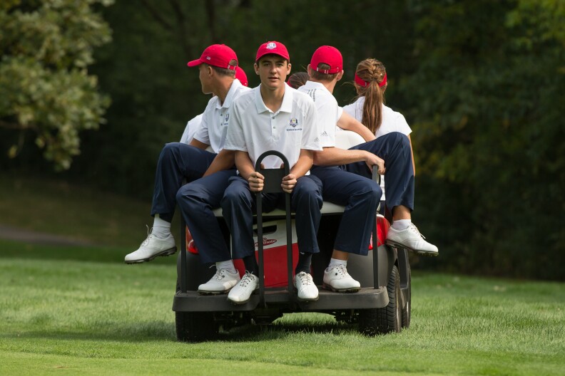 Scottie Scheffler of the United States rides on a cart with his teammates during the singles for the 8th Junior Ryder Cup