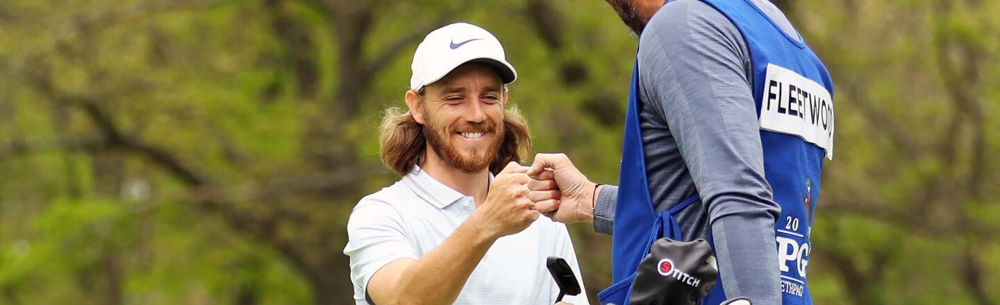 Tommy Fleetwood of England fist bumps caddie Ian Finnis after making a birdie on the ninth green during the second round of the 2019 PGA Championship